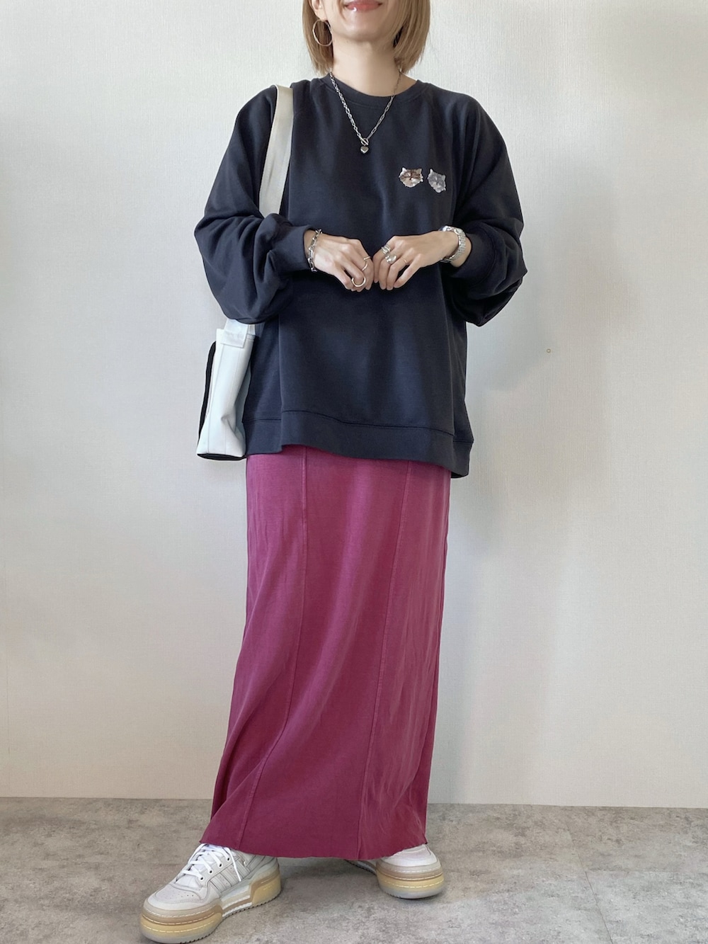 ピンク系のスカート、グレー系のスウェット、ホワイト系のショルダーバッグを着用したレディースの冬コーディネートの2枚目の写真