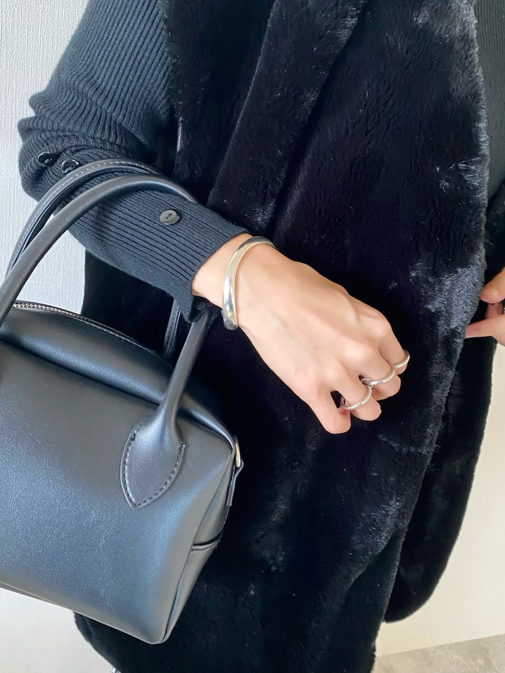 ブラック系のその他アウター、ブラック系のニット/セーター、ブラック系のバッグを着用したレディースの秋コーディネートの3枚目の写真