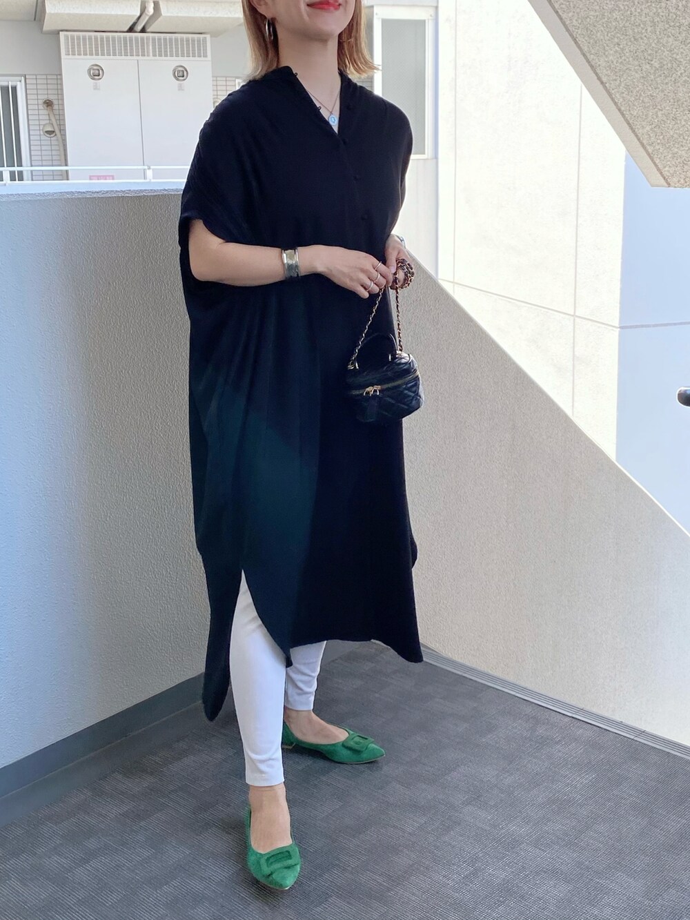 グリーン系のパンプス、ブラック系のショルダーバッグ、ブラック系のワンピースを着用したレディースの夏コーディネートの2枚目の写真