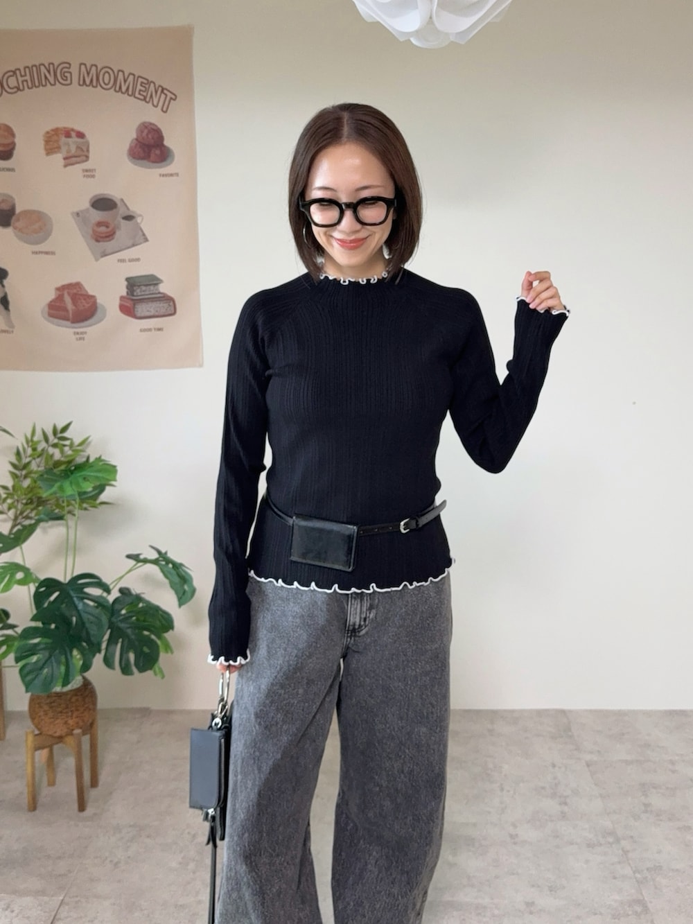 ブラック系のニット/セーター、グレー系のデニムパンツ、ブラック系のベルトを着用したレディースの秋コーディネートの3枚目の写真