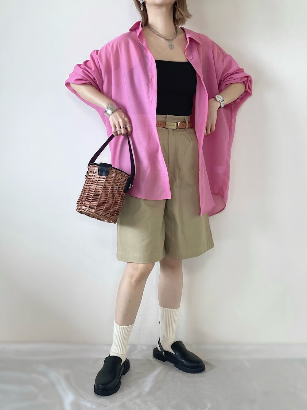 ブラック系のキャミソール、ピンク系のシャツ/ブラウス、ベージュ系のチノパンツを着用したレディースの春コーディネートの2枚目の写真