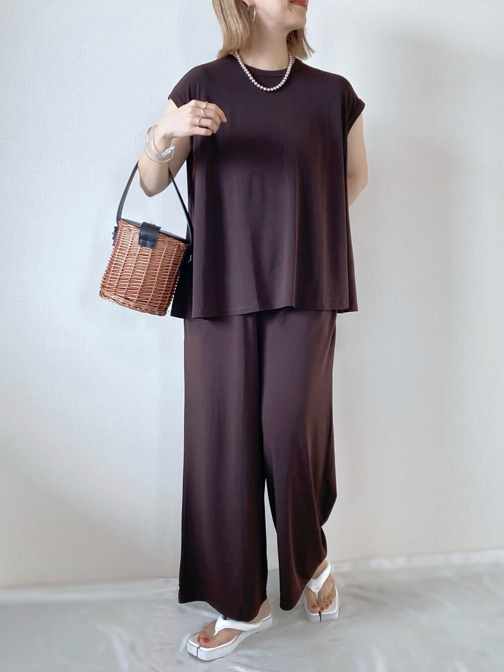 ブラック系のバッグ、ホワイト系のサンダル、ブラウン系のその他トップスを着用したレディースの夏コーディネートの3枚目の写真