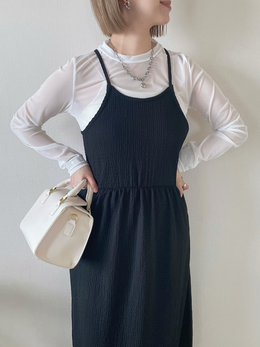 ブラック系のワンピース、ホワイト系のTシャツ/カットソー、ホワイト系のハンドバッグを着用したレディースの春コーディネートの4枚目の写真