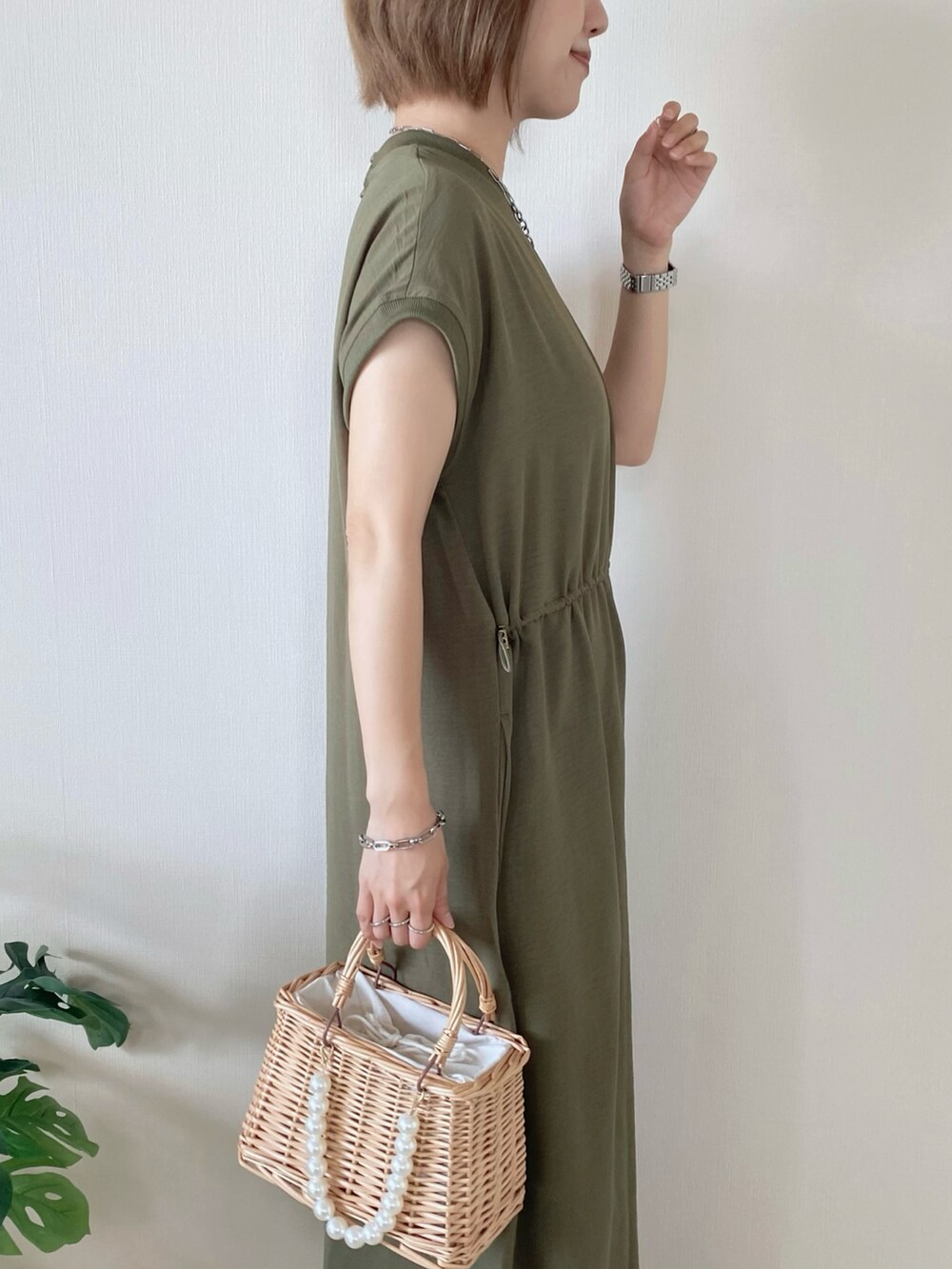 ベージュ系のかごバッグ、グリーン系のワンピース、ピンク系のサンダルを着用したレディースの夏コーディネートの5枚目の写真