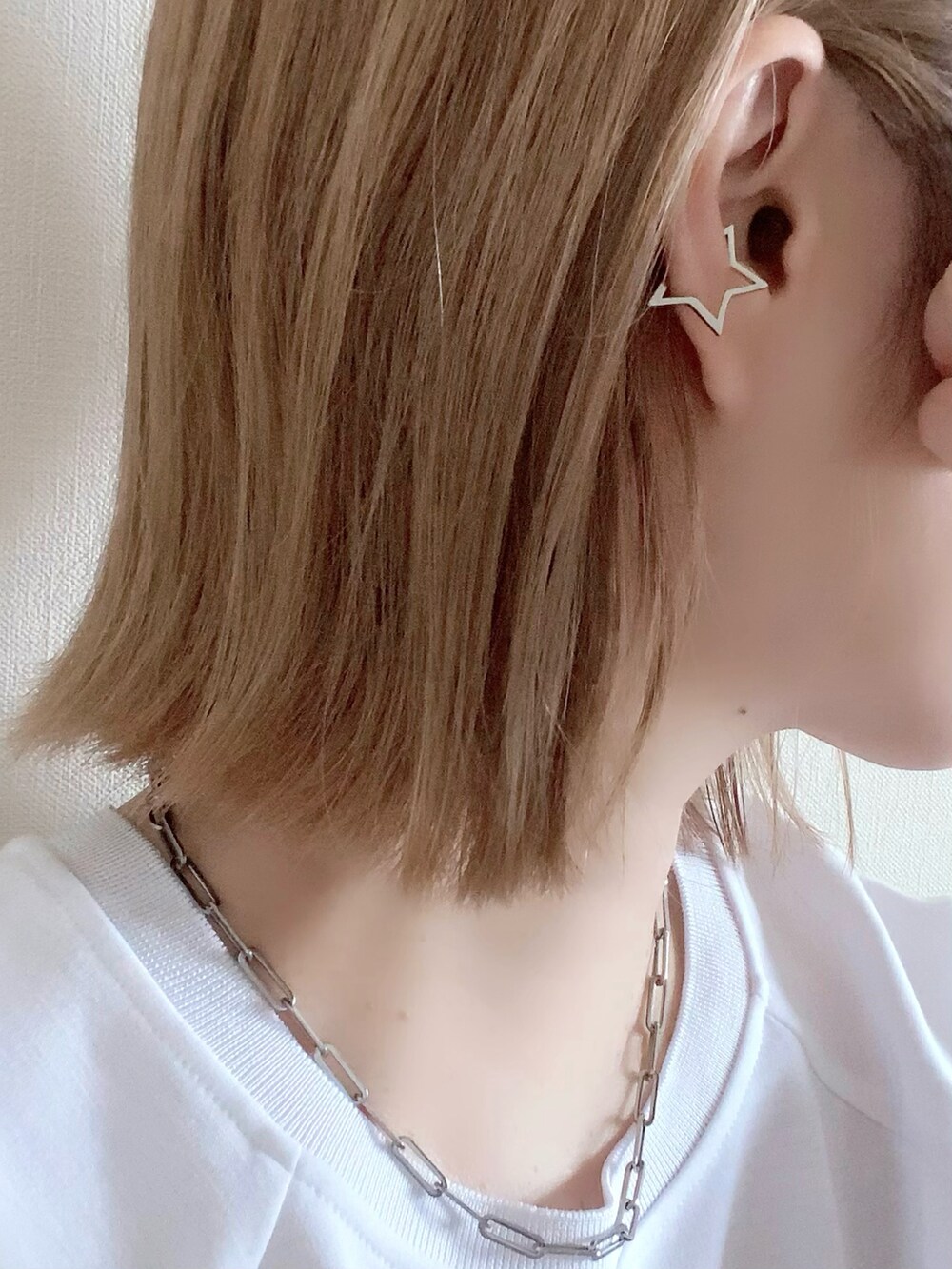 その他のイヤーカフ、イエロー系のキャップを着用したレディースの春コーディネートの3枚目の写真