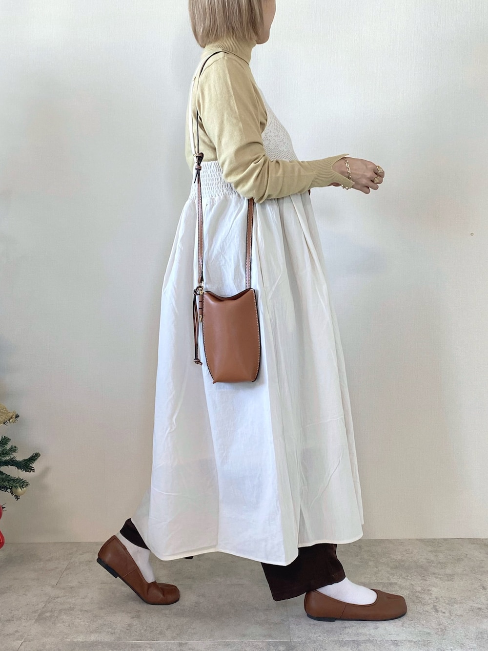 ホワイト系のワンピース、イエロー系のニット/セーター、ブラウン系のその他パンツを着用したレディースの冬コーディネートの3枚目の写真