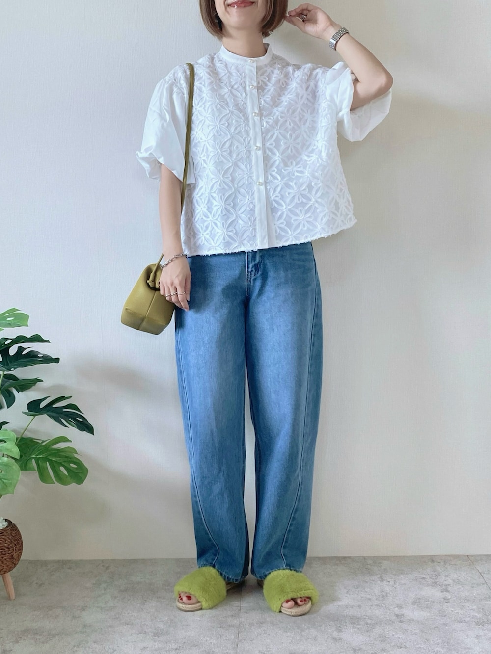 グリーン系のボストンバッグ、イエロー系のサンダル、ホワイト系のシャツ/ブラウスを着用したレディースの夏コーディネートの2枚目の写真