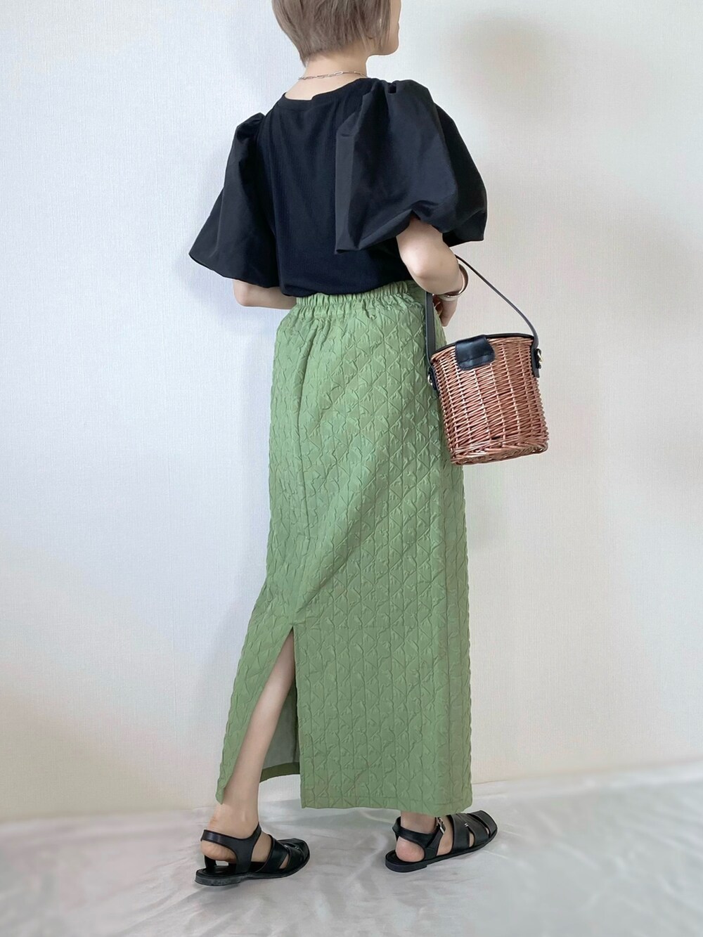 グリーン系のスカート、ブラック系のトップス、ブラック系のバッグを着用したレディースの夏コーディネートの3枚目の写真