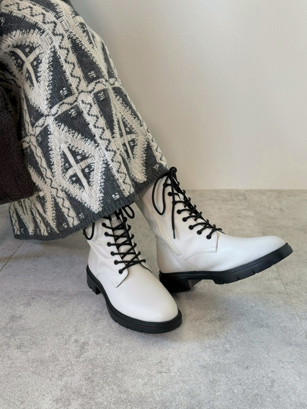 グレー系のピーコート、ブラック系のハンドバッグ、グレー系のスカートを着用したレディースの冬コーディネートの5枚目の写真