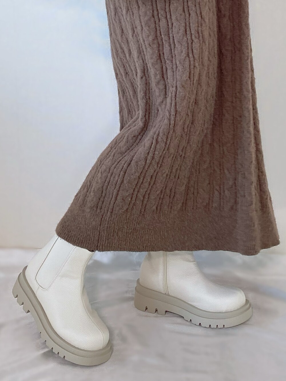 ベージュ系のバッグ、ブラウン系のワンピース、ホワイト系のブーツを着用したレディースの秋コーディネートの3枚目の写真