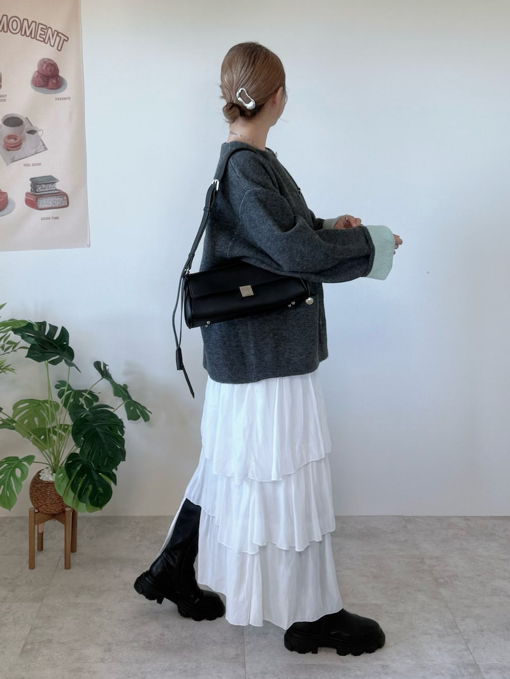 グレー系のカーディガン/ボレロ、ホワイト系のスカート、ブラック系のショルダーバッグを着用したレディースの秋コーディネートの2枚目の写真