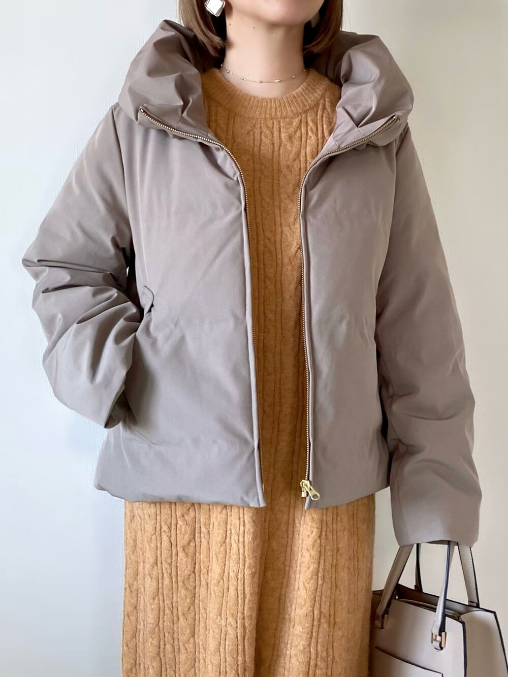 ブラウン系のダウンジャケット/コート、オレンジ系のワンピース、ベージュ系のバッグを着用したレディースの秋コーディネートの4枚目の写真