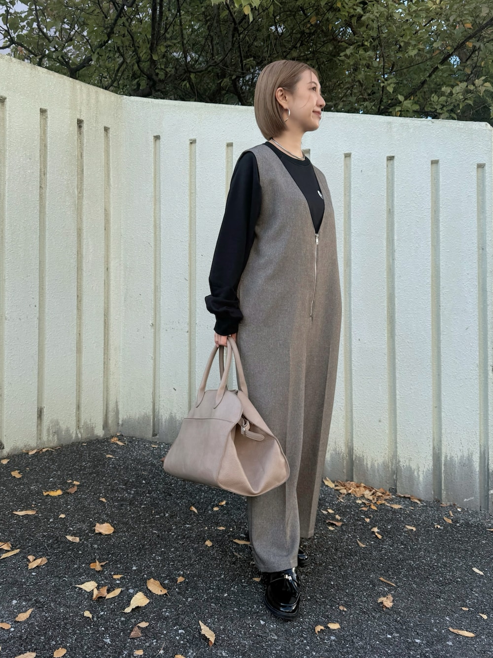 ベージュ系のボストンバッグ、ブラック系のローファー、ブラック系のスウェットを着用したレディースの冬コーディネートの3枚目の写真