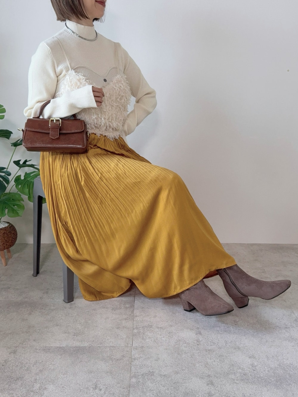 イエロー系のスカート、ブラウン系のハンドバッグ、ホワイト系のシャツ/ブラウスを着用したレディースの秋コーディネートの4枚目の写真