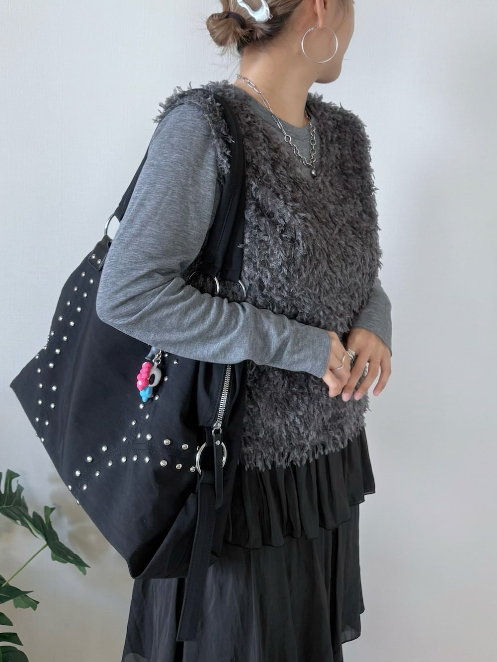 ブラック系のスカート、ブラック系のボストンバッグ、シルバー系のヘアピンを着用したレディースの秋コーディネートの5枚目の写真