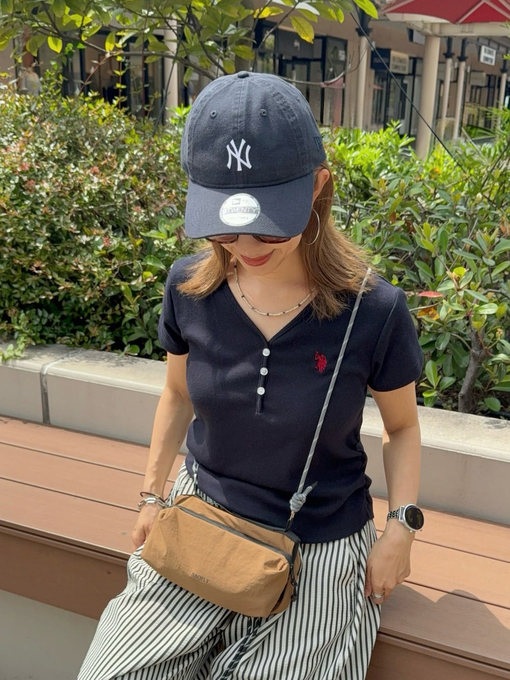 ブルー系のTシャツ/カットソー、ホワイト系のその他パンツ、ブラウン系のショルダーバッグを着用したレディースの夏コーディネートの2枚目の写真