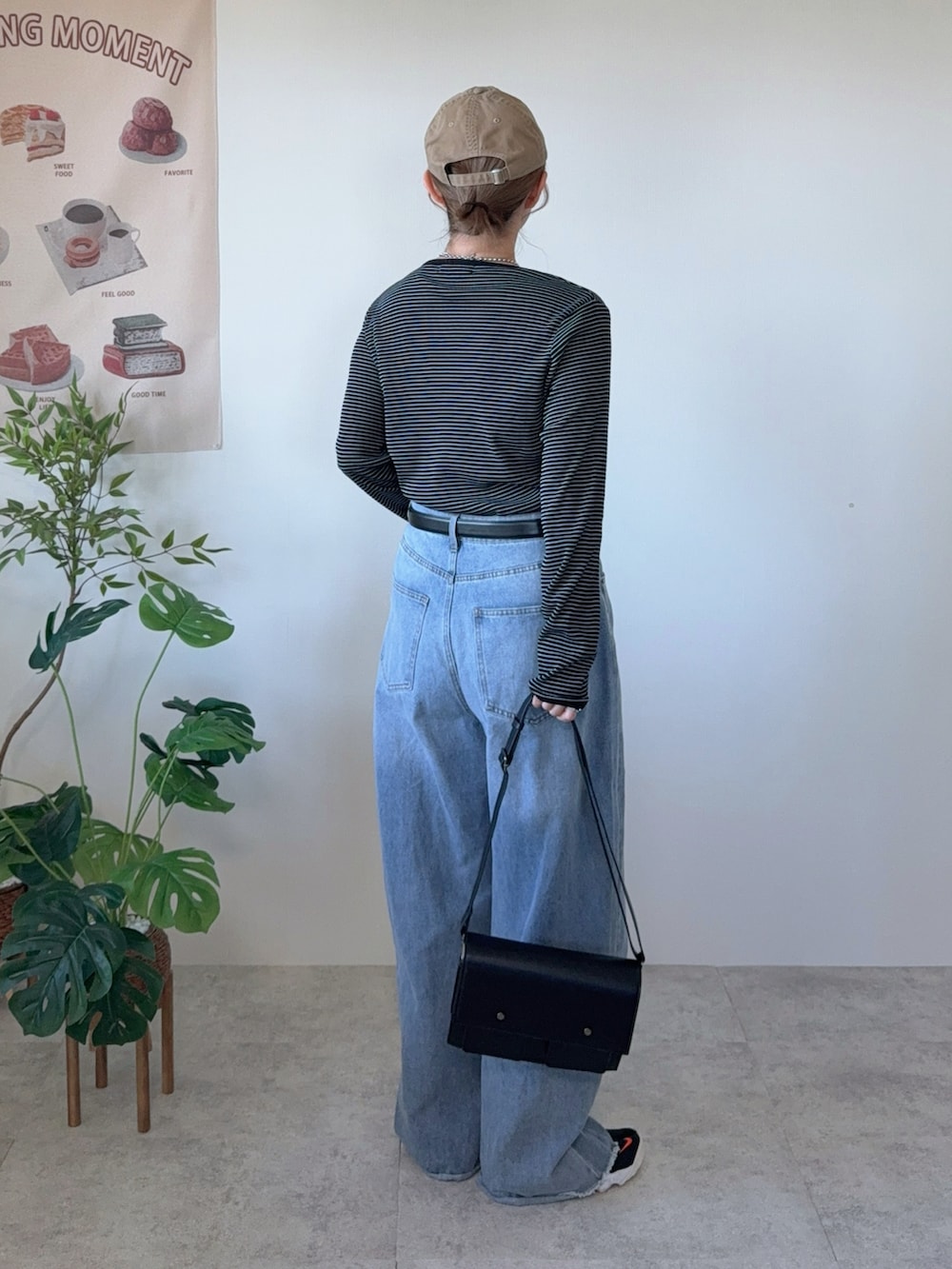 ブラック系のTシャツ/カットソー、ブラック系のショルダーバッグ、ブラック系のスニーカーを着用したレディースの冬コーディネートの3枚目の写真