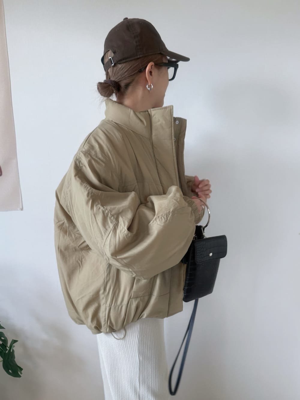 ベージュ系のダウンジャケット/コート、グレー系のスカート、ブラウン系のスウェットを着用したレディースの秋コーディネートの5枚目の写真