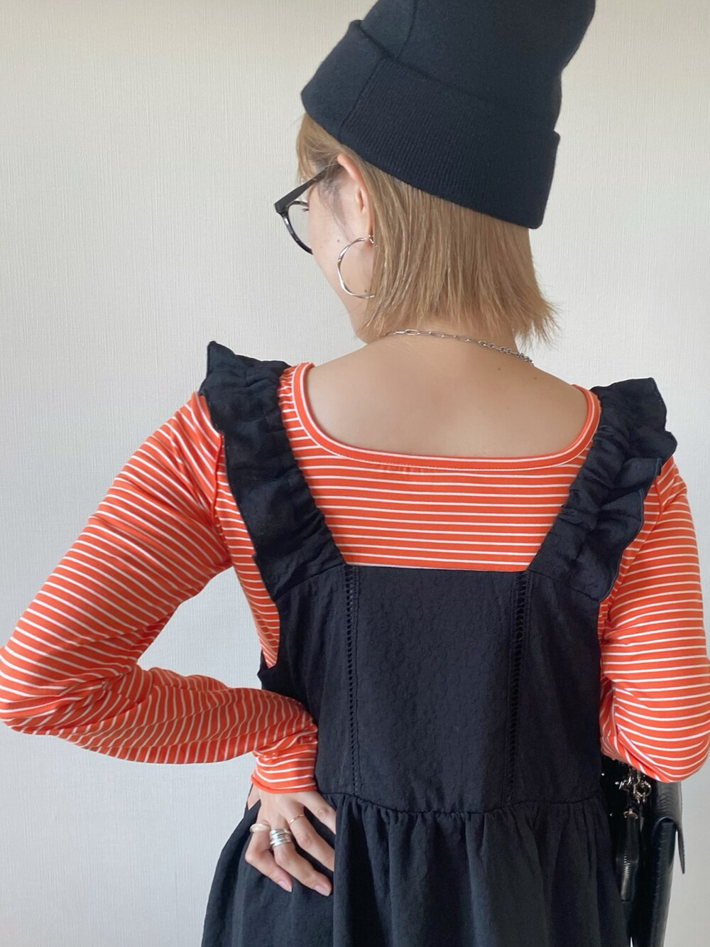 ブラック系のワンピース、オレンジ系のTシャツ/カットソー、ブラック系のローファーを着用したレディースの秋コーディネートの5枚目の写真