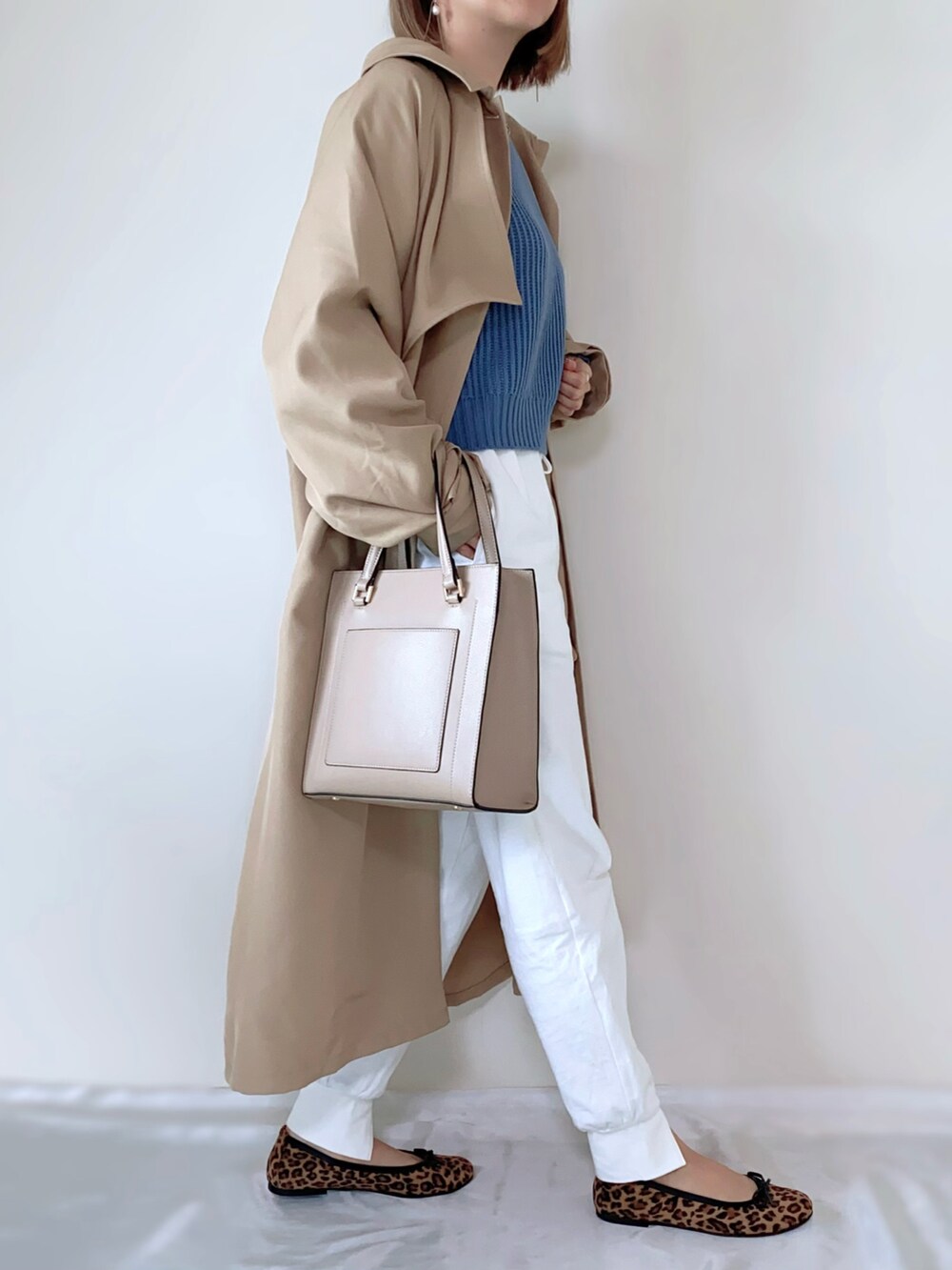 ブルー系のニット/セーター、ホワイト系のその他パンツ、ベージュ系のバッグを着用したレディースの春コーディネートの3枚目の写真