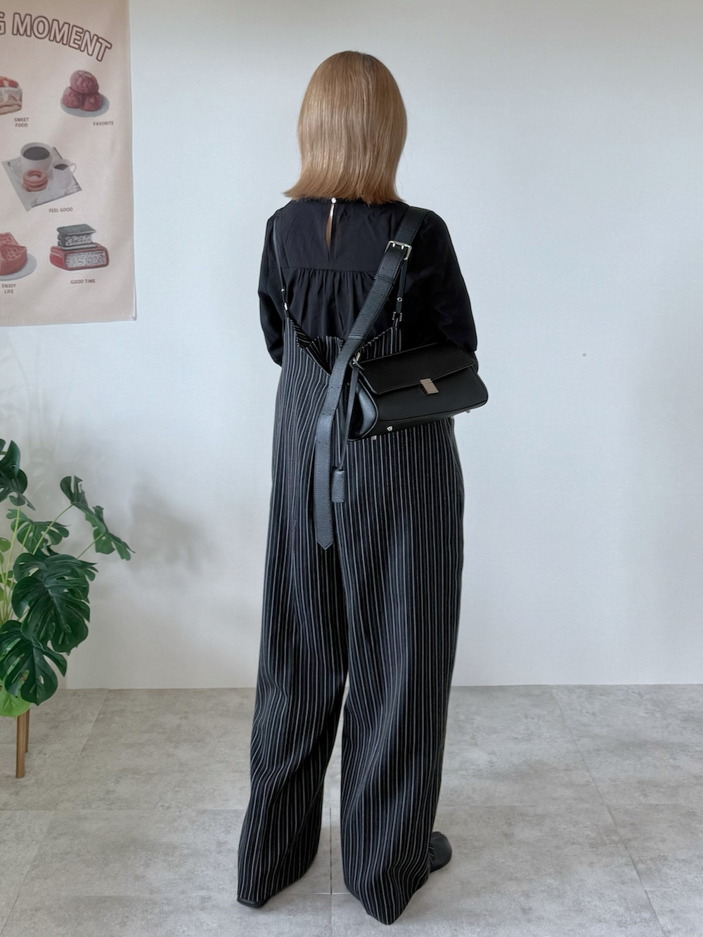 ブラック系のブーツ、ブラック系のシャツ/ブラウス、ブラック系のショルダーバッグを着用したレディースの秋コーディネートの3枚目の写真