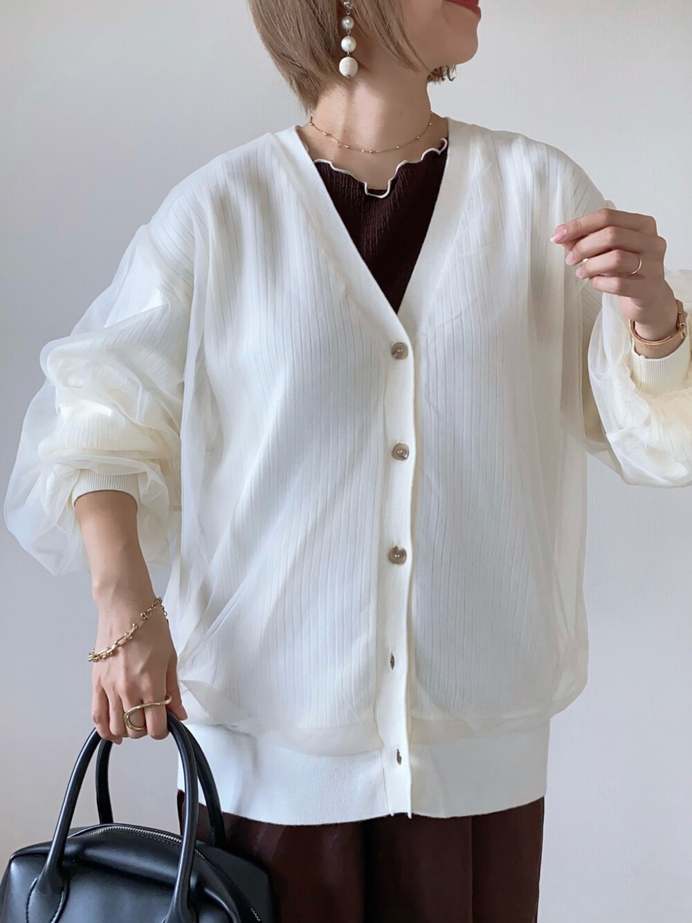 ホワイト系のカーディガン/ボレロ、ブラウン系のその他パンツ、ブラウン系のバレエシューズを着用したレディースの秋コーディネートの3枚目の写真