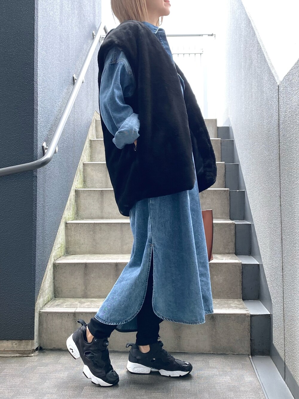 ブルー系のシャツワンピース、ブラック系のスニーカー、ブラック系のその他アウターを着用したレディースの秋コーディネートの2枚目の写真