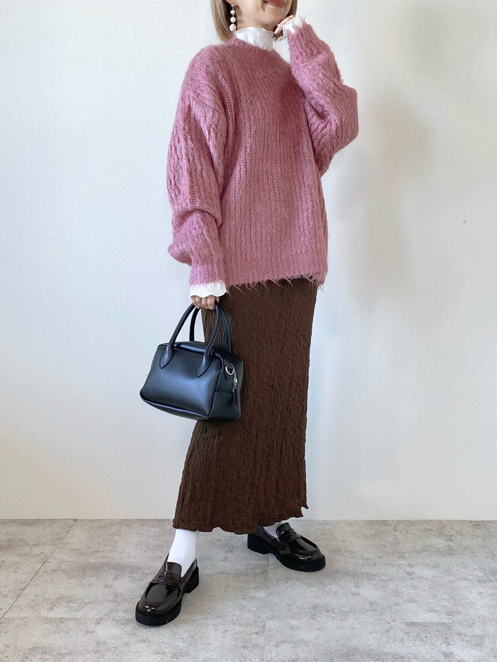 ブラウン系のスカート、ブラック系のバッグ、ホワイト系のTシャツ/カットソーを着用したレディースの秋コーディネートの5枚目の写真