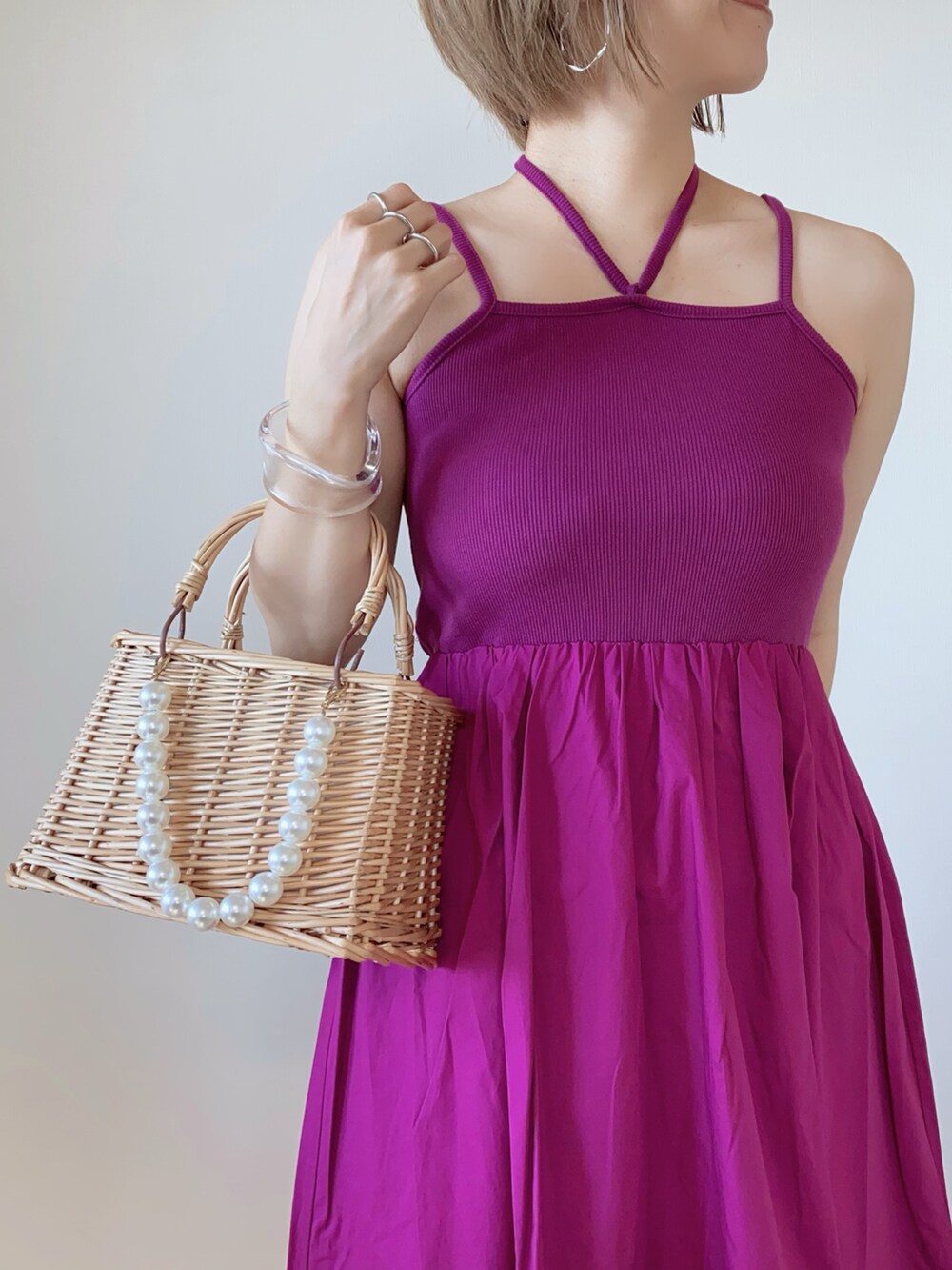 ピンク系のワンピース、ベージュ系のかごバッグ、ブルー系のベストを着用したレディースの夏コーディネートの5枚目の写真