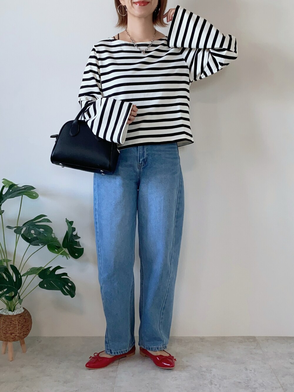 ブラック系のボストンバッグ、レッド系のバレエシューズ、ブラック系のTシャツ/カットソーを着用したレディースの夏コーディネートの2枚目の写真