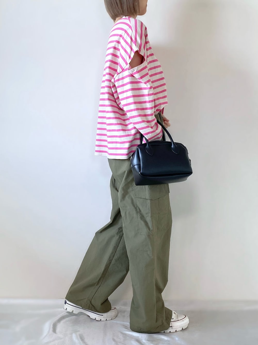 ブラック系のバッグ、グリーン系のカーゴパンツ、ホワイト系のスニーカーを着用したレディースの冬コーディネートの3枚目の写真