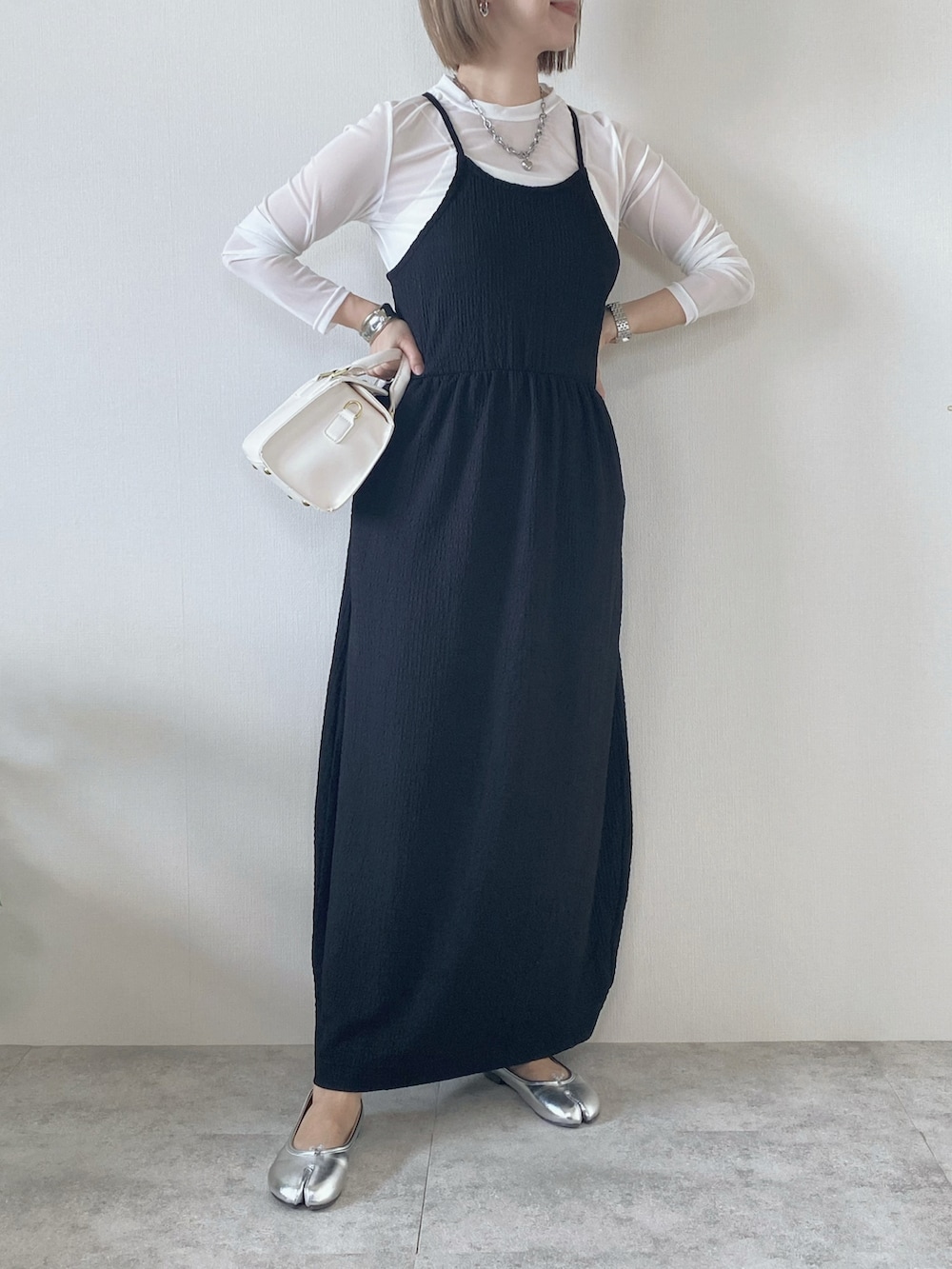 ブラック系のワンピース、ホワイト系のTシャツ/カットソー、ホワイト系のハンドバッグを着用したレディースの春コーディネートの5枚目の写真