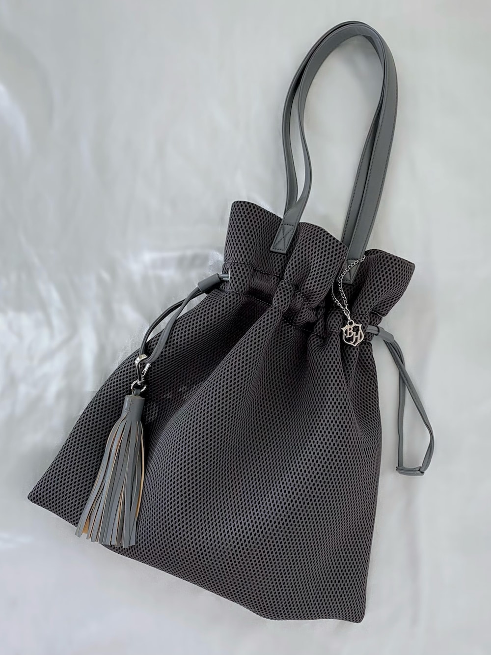 グレー系のバッグ、グレー系のTシャツ/カットソー、ブラック系のスカートを着用したレディースの夏コーディネートの3枚目の写真