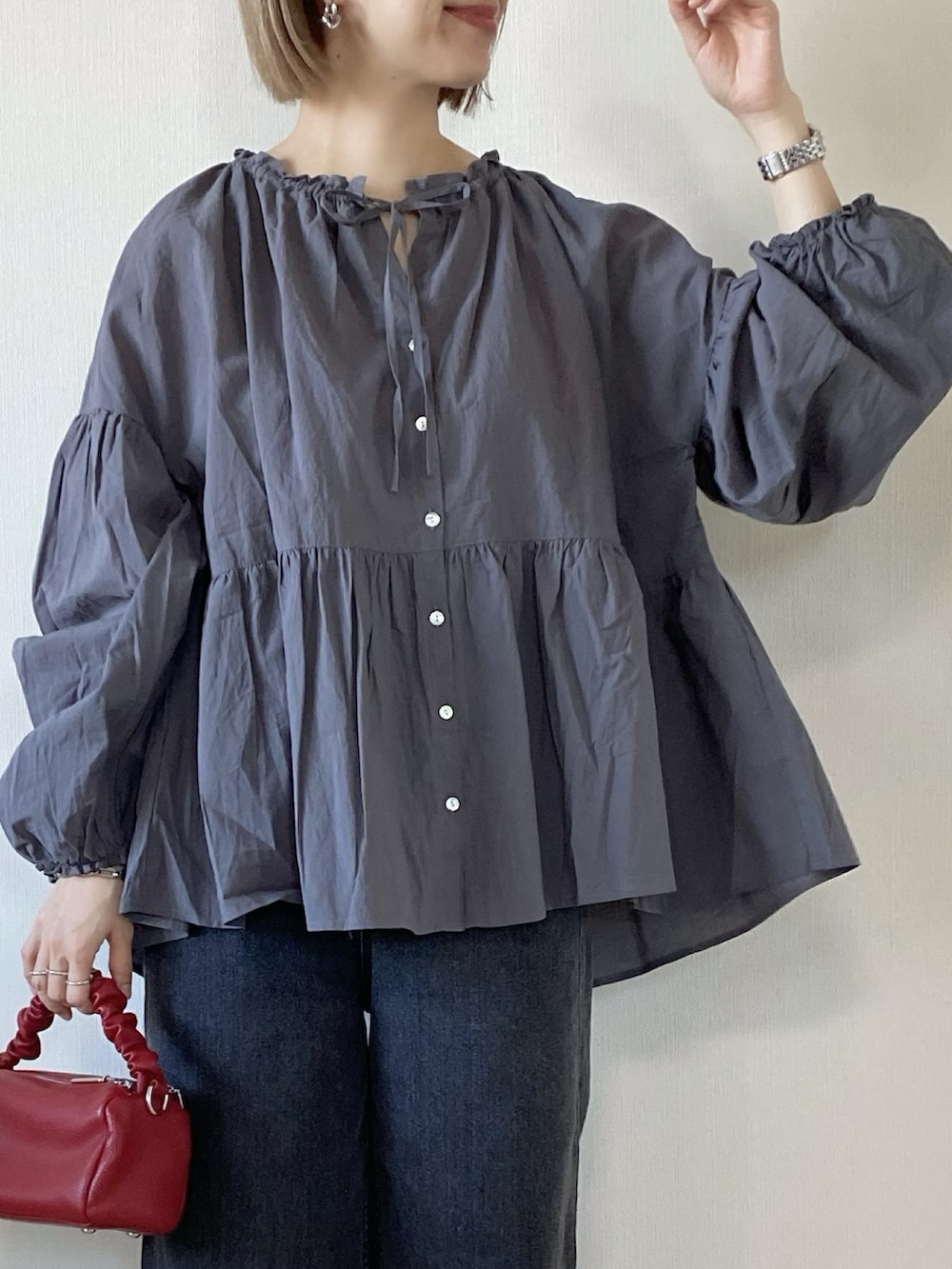 グレー系のシャツ/ブラウス、ブラック系のデニムパンツ、レッド系のボストンバッグを着用したレディースの春コーディネートの4枚目の写真