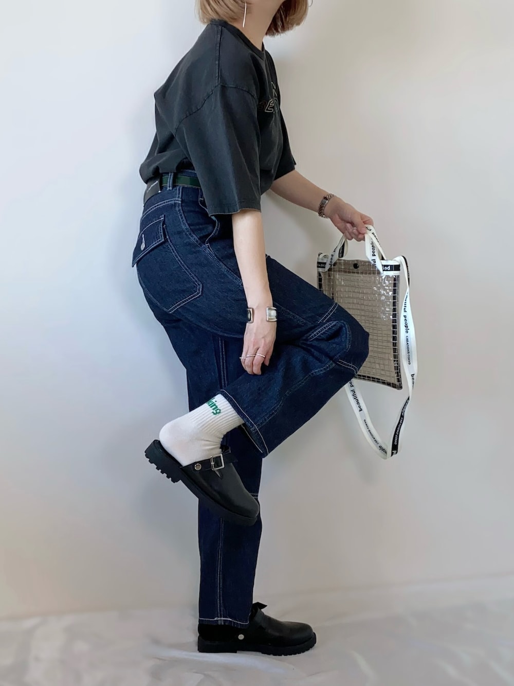 ブルー系のパンツ、ブラック系のTシャツ/カットソー、ブラック系のショルダーバッグを着用したレディースの春コーディネートの3枚目の写真