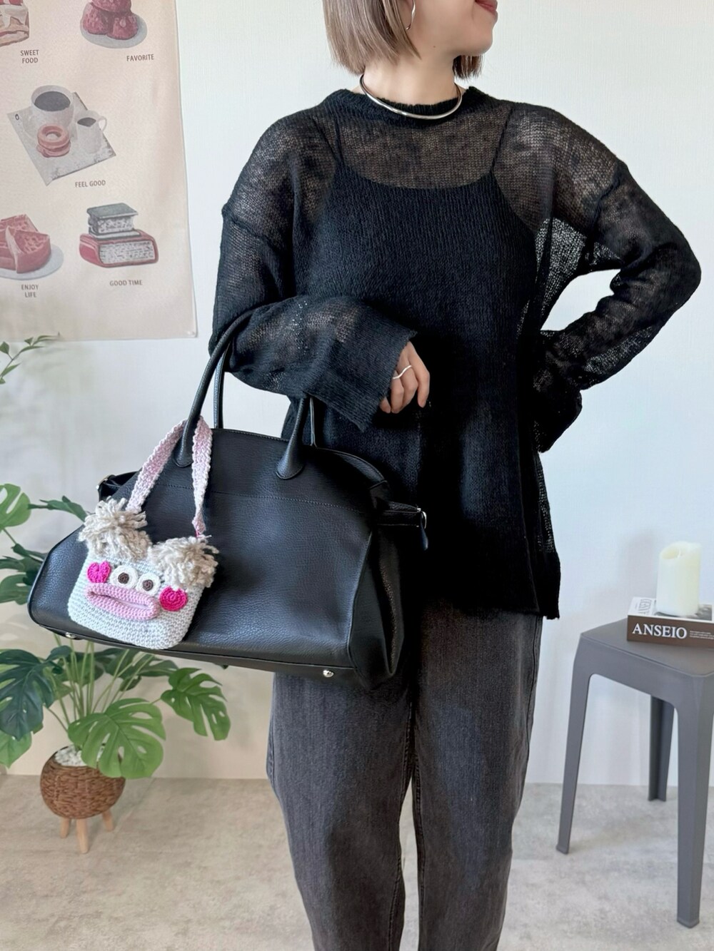 ブラック系のニット/セーター、ブラック系のボストンバッグ、ブラック系のデニムパンツを着用したレディースの冬コーディネートの2枚目の写真