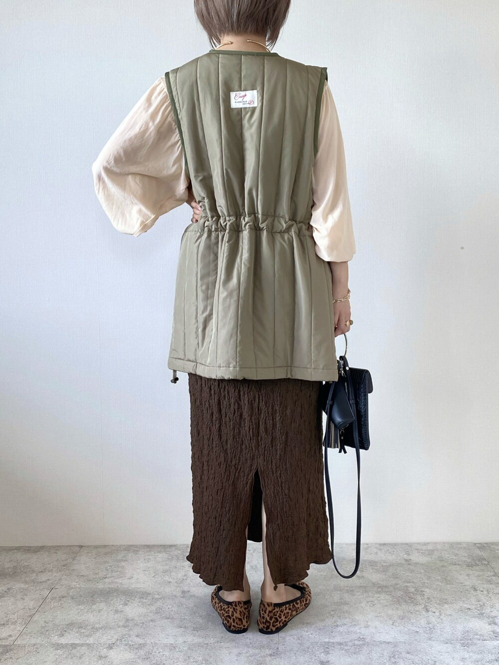 ベージュ系のTシャツ/カットソー、ブラウン系のスカート、ブラウン系のバレエシューズを着用したレディースの秋コーディネートの3枚目の写真