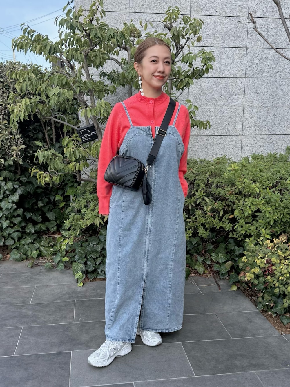 ブルー系のワンピース、ホワイト系のスニーカー、ピンク系のカーディガン/ボレロを着用したレディースの春コーディネートの2枚目の写真