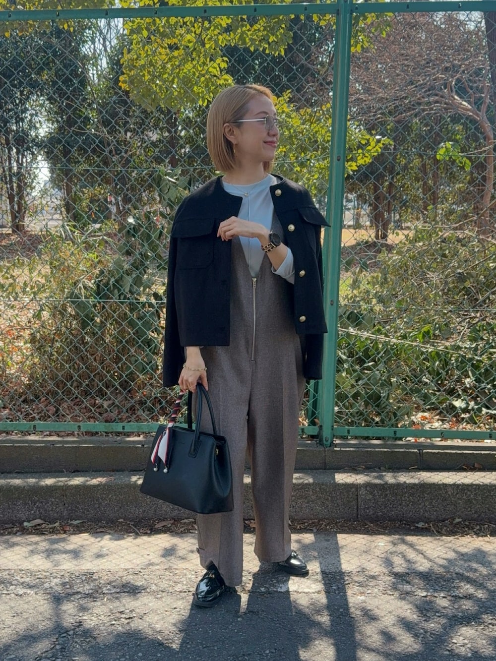 ブラウン系のつなぎ/オールインワン、ブラック系のローファー、ブラック系のハンドバッグを着用したレディースの春コーディネートの2枚目の写真