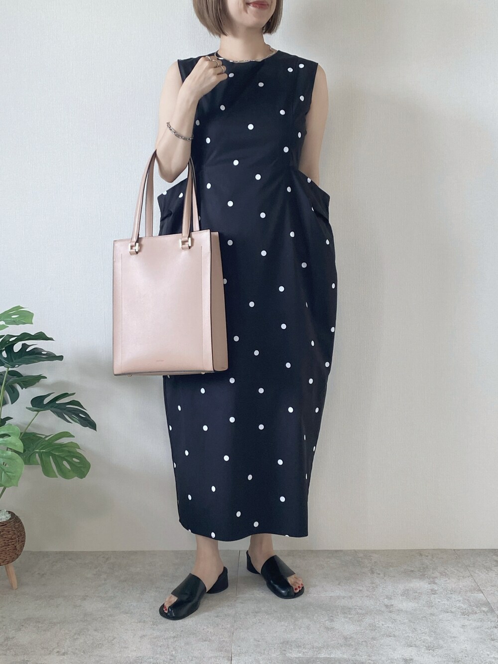 ブラック系のサンダル、ブラック系のワンピース、ピンク系のトートバッグを着用したレディースの夏コーディネートの4枚目の写真