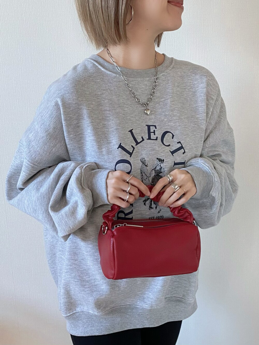 グレー系のスウェット、レッド系のボストンバッグ、ブラック系のパンプスを着用したレディースの冬コーディネートの3枚目の写真