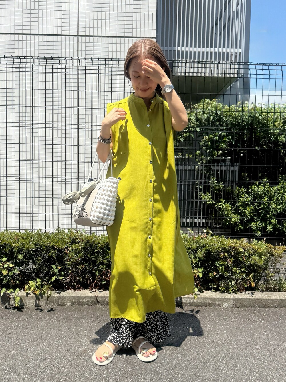 グリーン系のワンピース、ホワイト系のサンダル、ブラック系のその他パンツを着用したレディースの夏コーディネートの3枚目の写真