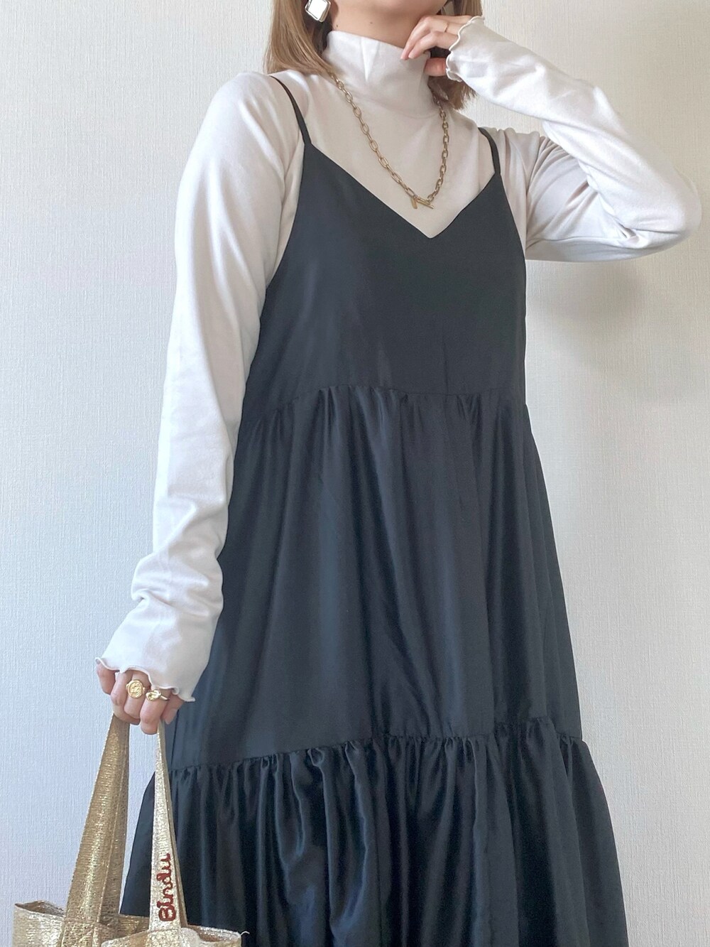 ゴールド系のトートバッグ、グレー系のワンピース、ホワイト系のトップスを着用したレディースの春コーディネートの4枚目の写真