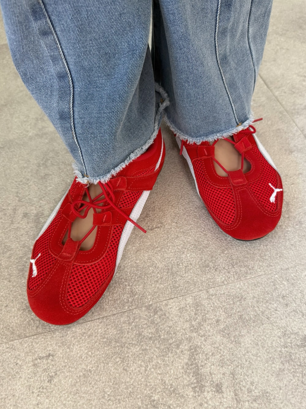 レッド系のスニーカー、ブラック系のTシャツ/カットソー、ブラック系のショルダーバッグを着用したレディースの春コーディネートの5枚目の写真