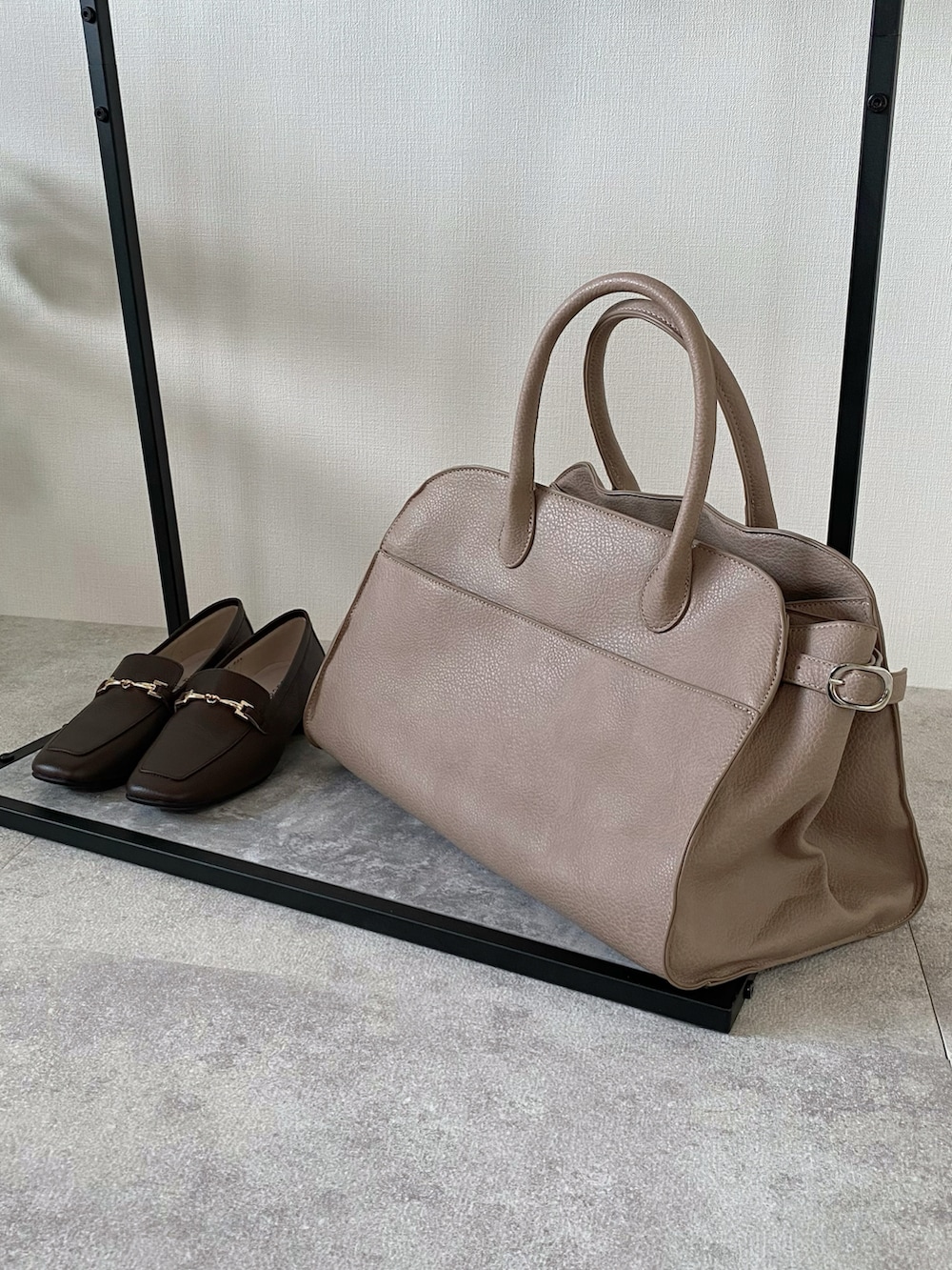 ブラック系のワンピース、ベージュ系のボストンバッグ、ブラウン系のローファーを着用したレディースの秋コーディネートの5枚目の写真