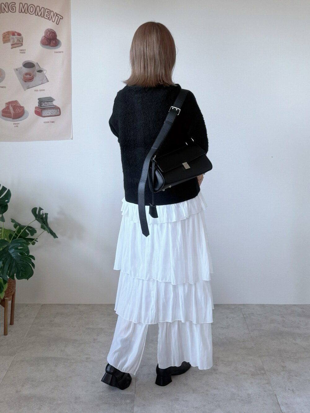 ブラック系のブーツ、ホワイト系のスカート、ブラック系のカーディガン/ボレロを着用したレディースの秋コーディネートの5枚目の写真