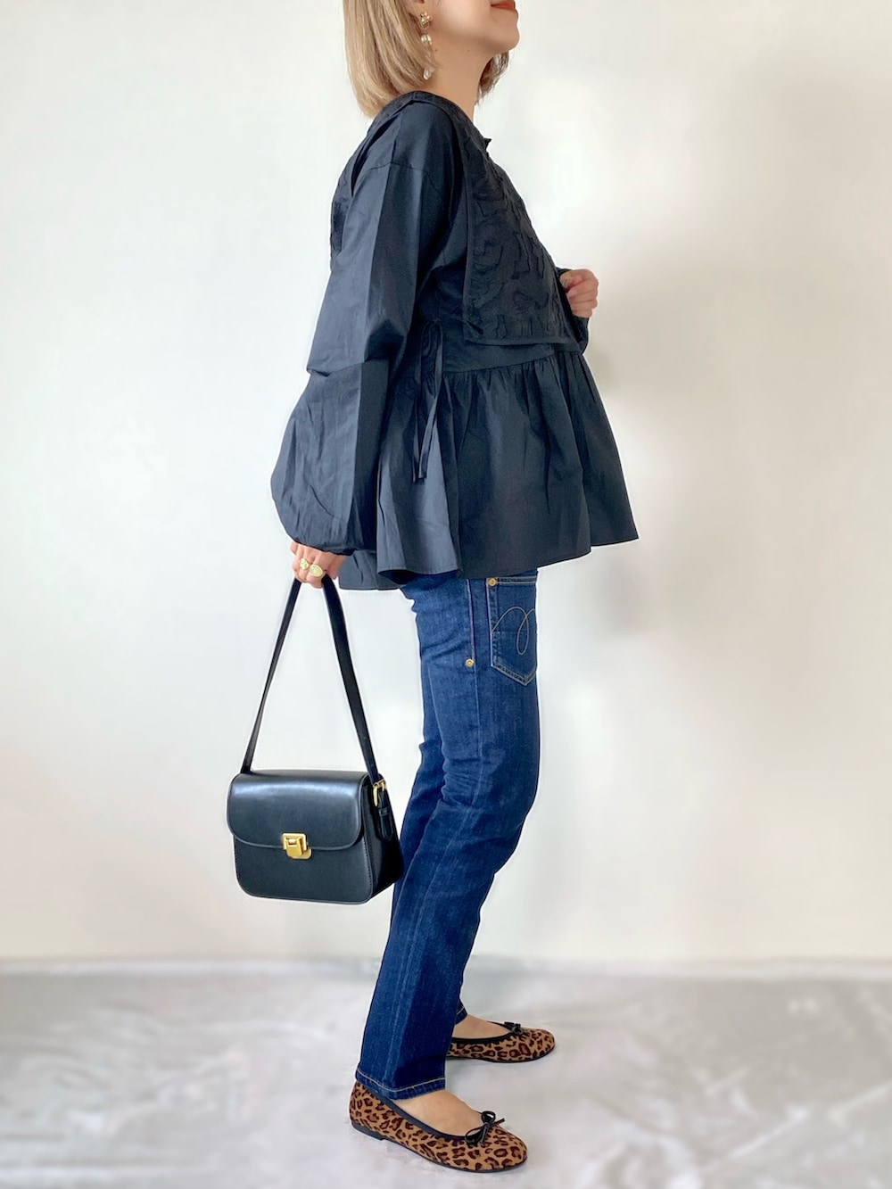 ブラック系のシャツ/ブラウス、ブラック系のショルダーバッグ、ブラウン系のバレエシューズを着用したレディースの秋コーディネートの2枚目の写真