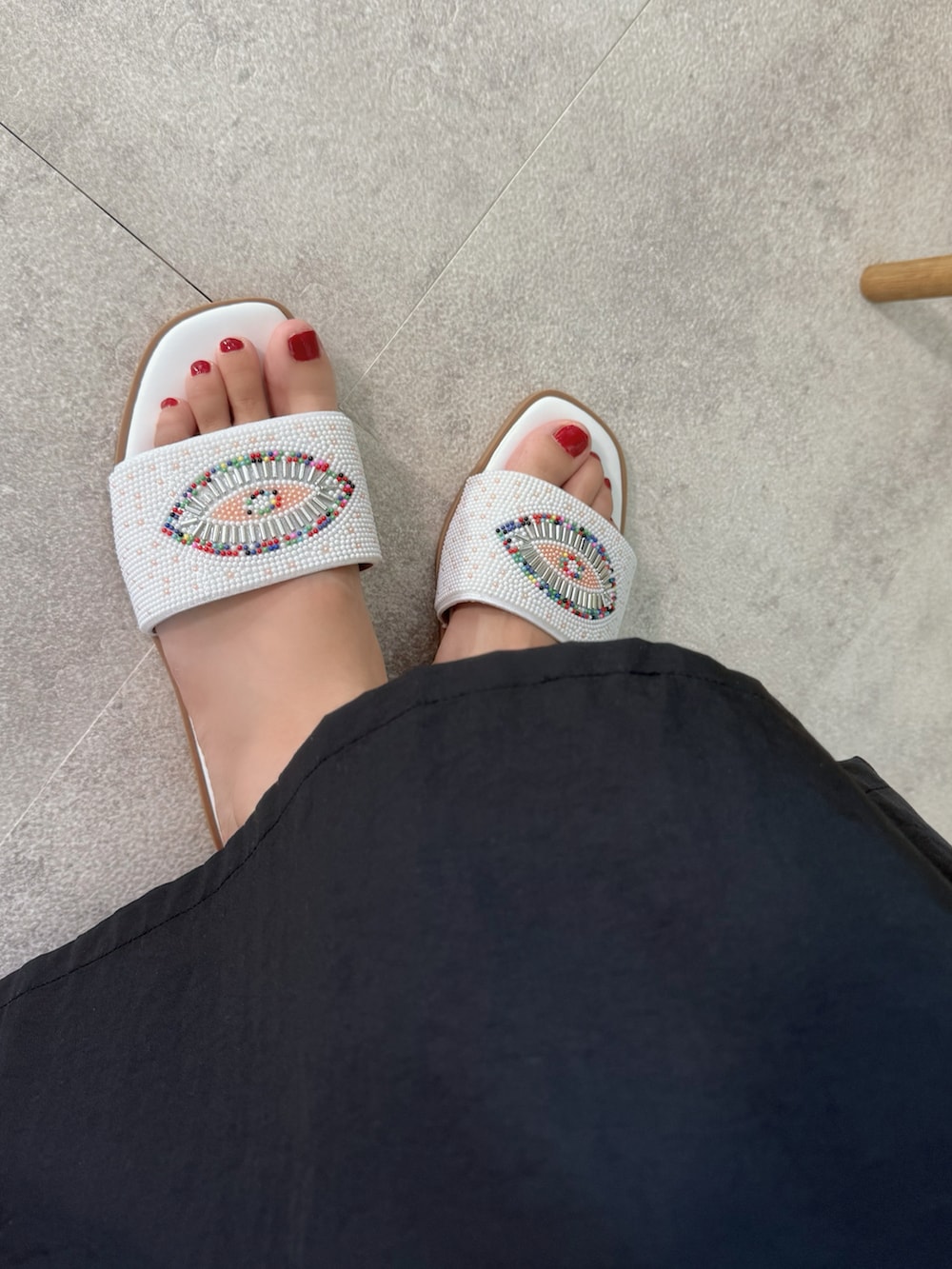 ホワイト系のサンダル、ホワイト系のかごバッグ、シルバー系のネックレスを着用したレディースの夏コーディネートの4枚目の写真