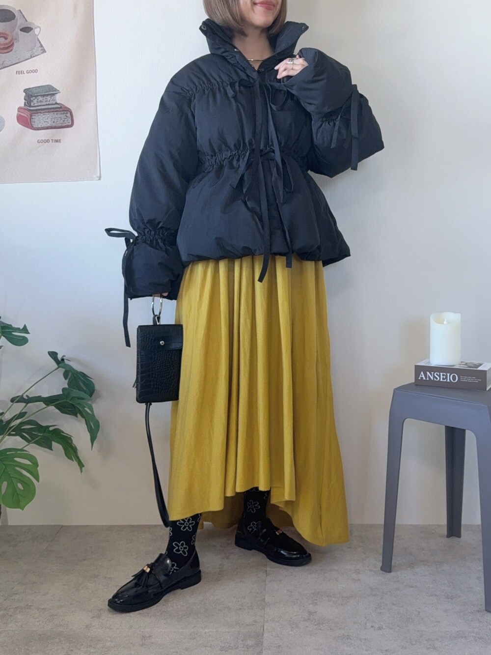 ブラック系のダウンジャケット/コート、ブラック系のローファーを着用したレディースの冬コーディネートの5枚目の写真