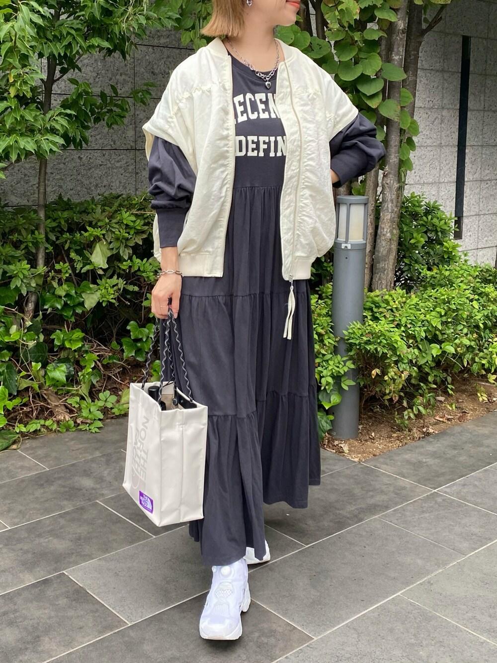 グレー系のワンピース、ベージュ系のトートバッグ、ホワイト系のスニーカーを着用したレディースの秋コーディネートの4枚目の写真